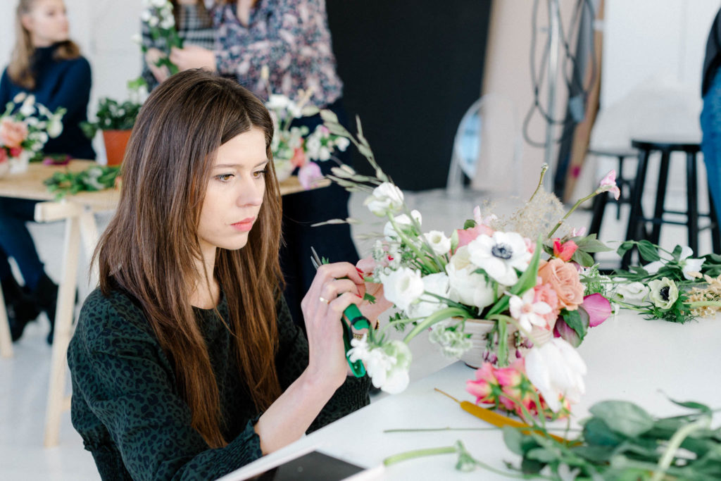Dziewczyna układająca kompozycję na warsztatach.